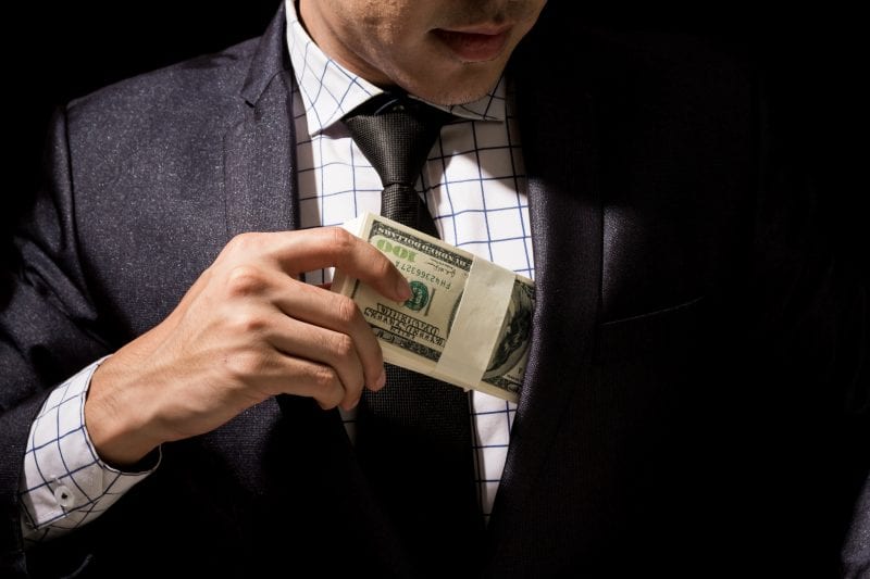 Man putting money in suit pocket